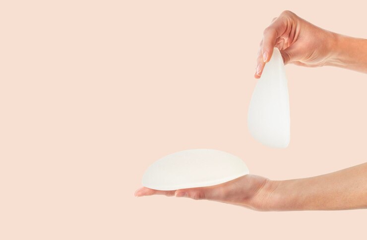 丸い女性の手と解剖学的な乳房インプラント 整形外科