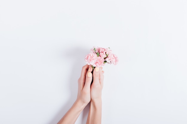 Female hands holding a small bouquet of pink flowers