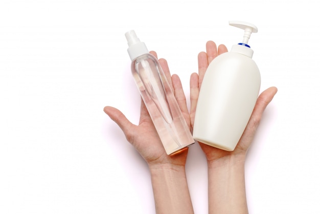 female hands holding soap and hand sanitizer spray dispenser isolated on white background with clipping path