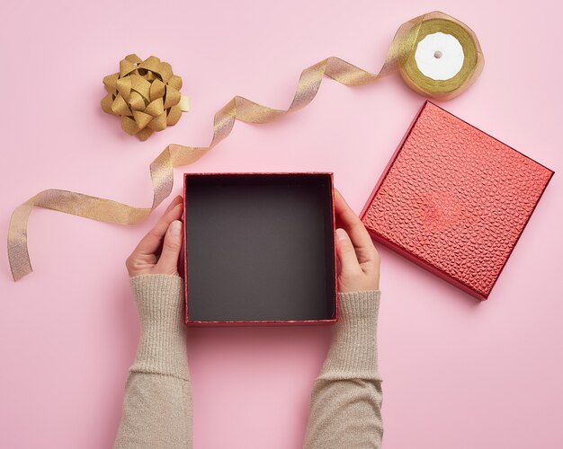 female hands holding a square empty gift box