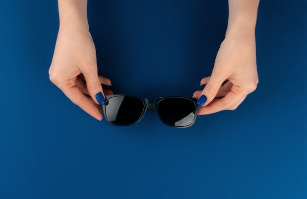 Female hands holding sunglasses