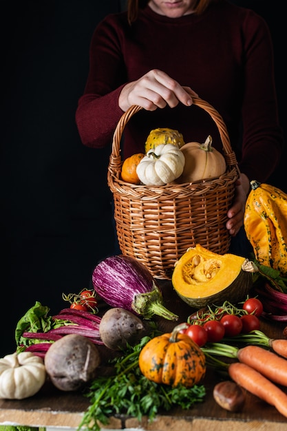 Female hands holding wicker basket with vegetables assortment