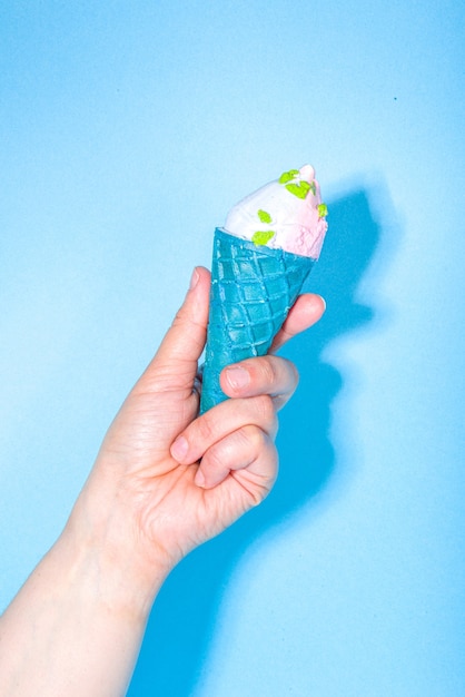 Female hands holds various ice cream on blue background