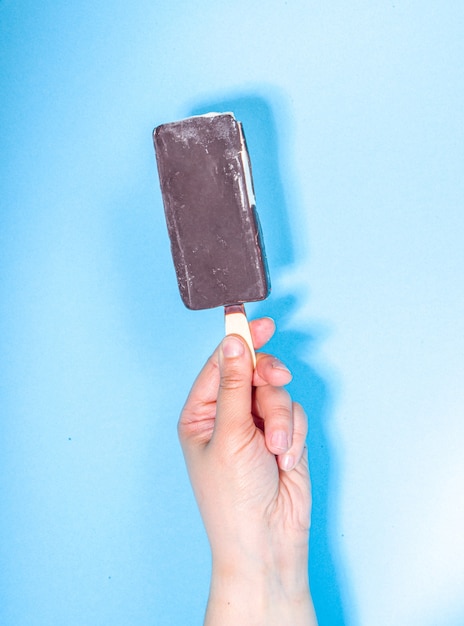 Female hands holds various ice cream on blue background