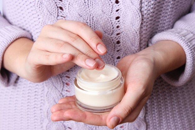 Female hands and jar of cream closeup with place to text