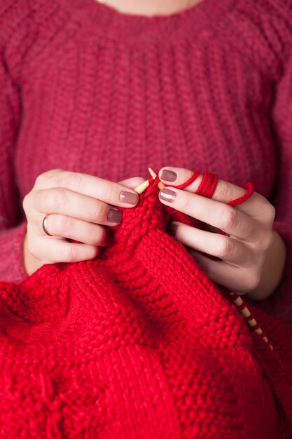 Женские руки вяжет свитер