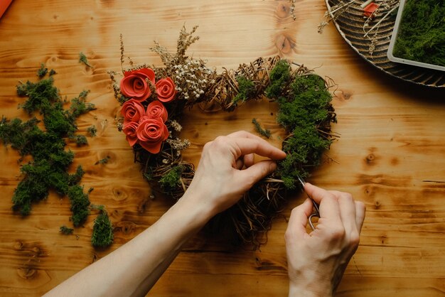 Female hands makes spring floral wreath