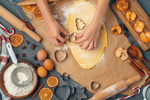 female hands making cookies from fresh dough at home