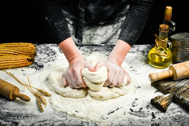 照片女性手做面团面包与面粉飞溅烹饪背景