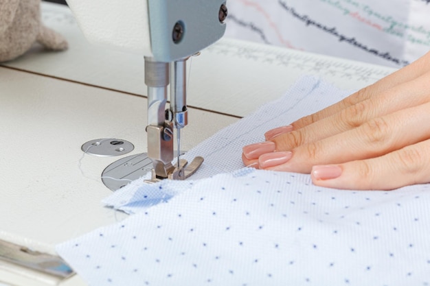 Female hands of a master tailor at work a sewing machine needle