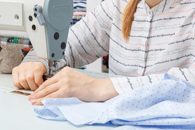 Female hands of a master tailor at work a sewing machine needle