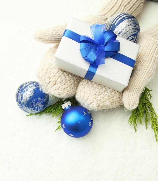 Female hands  in mittens with gift box, on white background