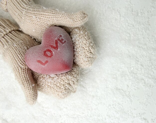 Female hands in mittens with red heart, close-up