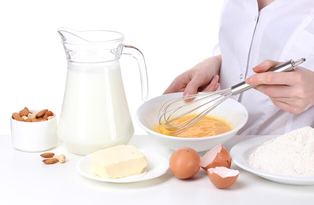 Female hands mixing eggs in bowl isolated on white