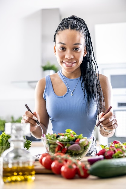 Female hands mixing a healthy spring salad made from various ingredients Concept of healthy lifestyle