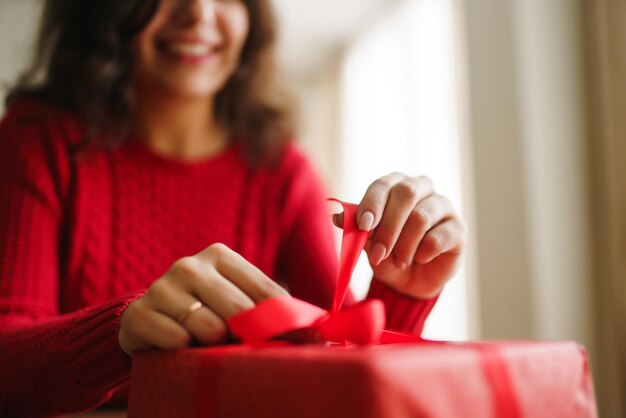 Female hands opening red gift box Unpacking a gift Valentines day celebration concept