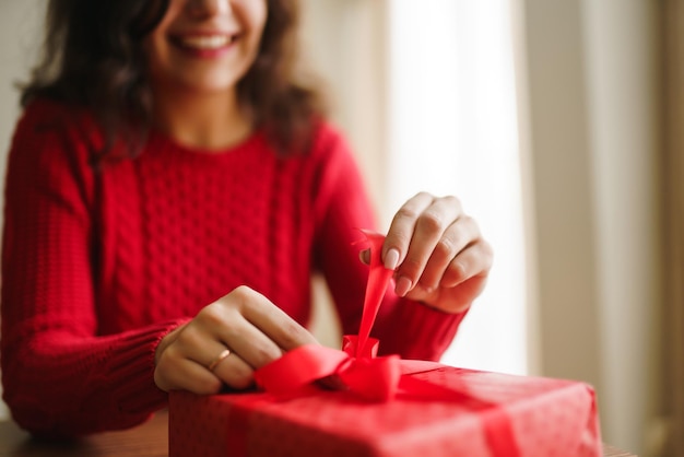 Female hands opening red gift box Unpacking a gift Valentines day celebration concept