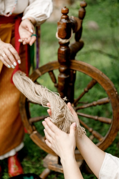 Photo female hands passing material for weaving and spindle