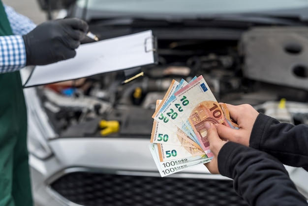 Female hands paying for car service to worker