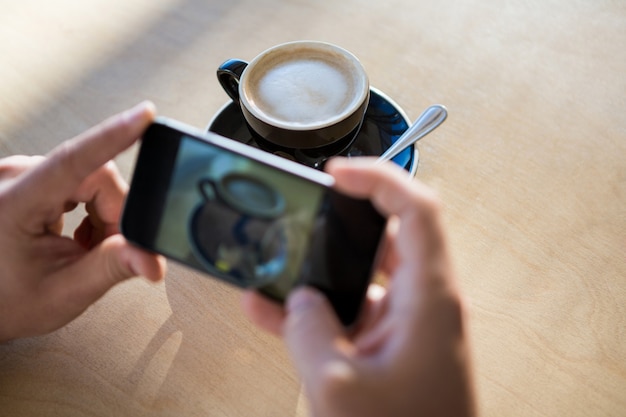 Female hands photographing a coffee cup