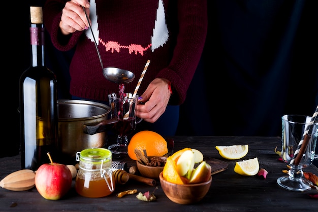 Female hands pouring hot mulled wine