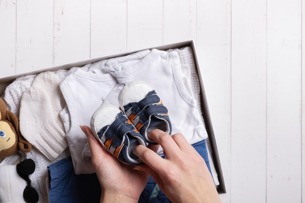 Female hands put children's clothes shoes and toys into donation box Second hand clothing recycle reuse concept