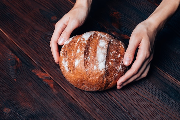 Female hands put on the table fresh bread