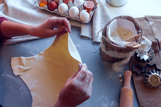 Female hands roll out the dough