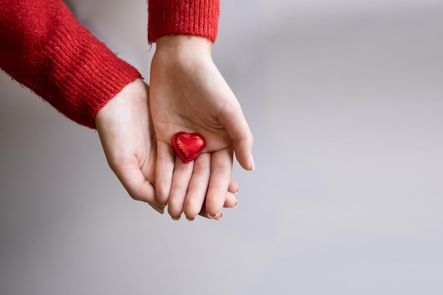 사진 사랑 발렌타인 개념의 밝은 배경 기호에 고립 된 심장 모양을 보여주는 여성 손