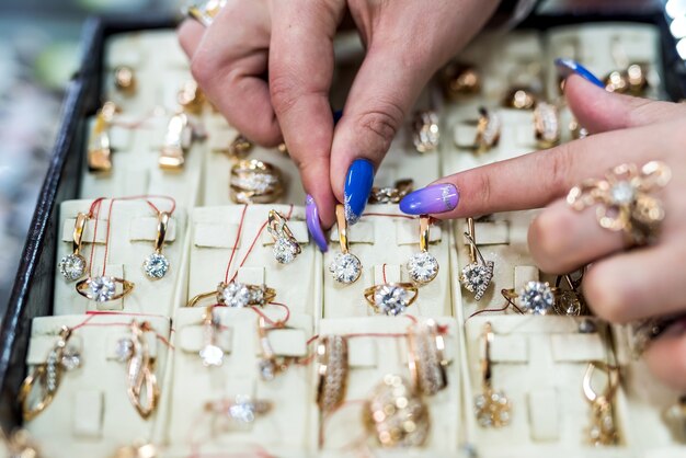 Female hands showing golden jewellery in shop