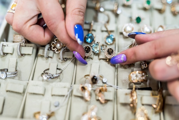 Female hands showing golden jewellery in shop