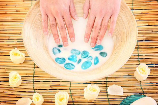 female hands soaking in a bowl of milk