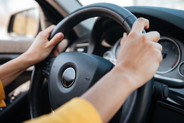 Photo female hands on steering wheel while driving a car