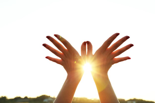 Photo female hands on sunny sky background