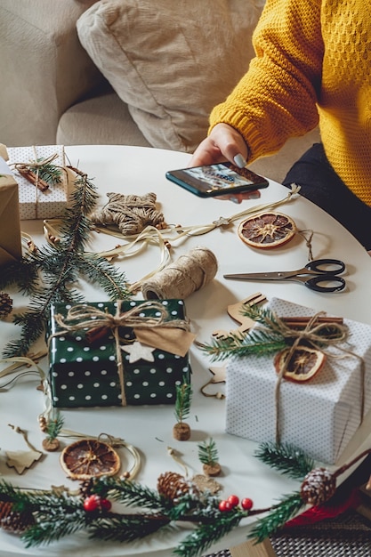 女性の手がクリスマスデコレーションの携帯電話で写真を撮る