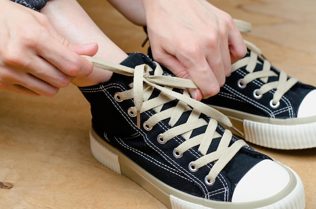 Female hands tying shoelaces on sneakers closeup