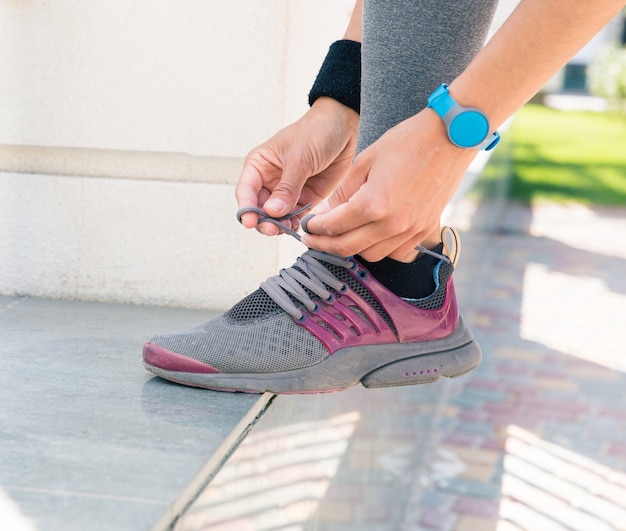 Photo female hands tying shoelaces