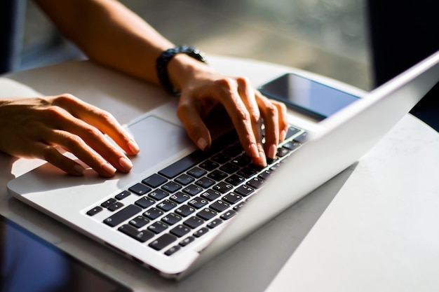 Female hands typing on a laptop close up