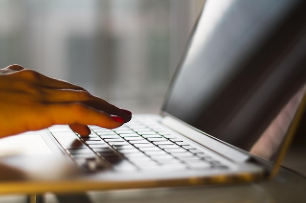 Female hands typing at laptop shallow depth of field