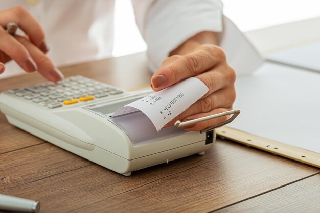 Female hands using adding machine