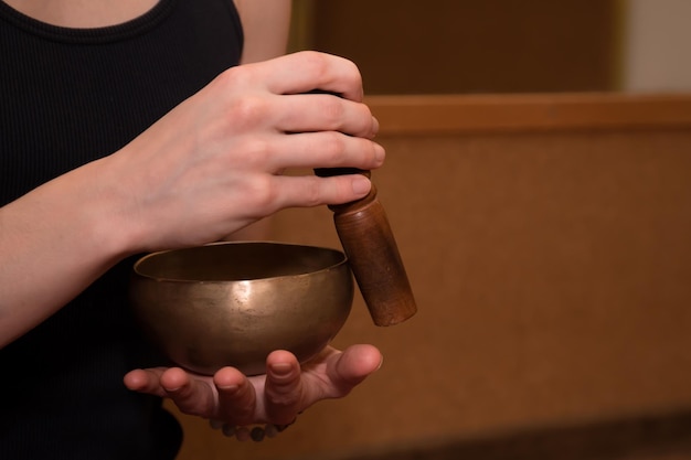 Female hands using singing bowl for relaxation and meditation