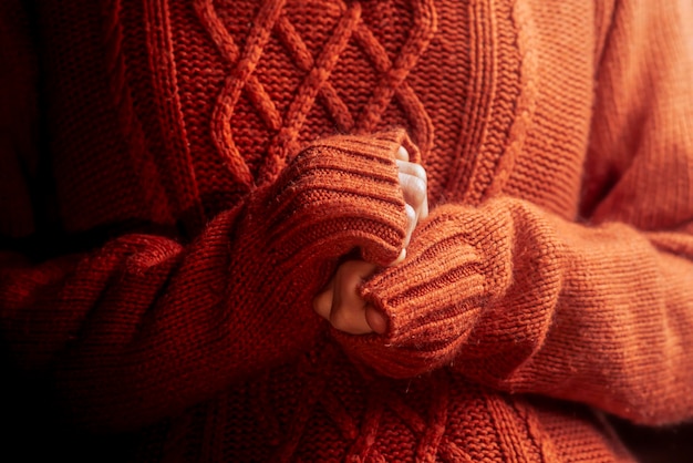 Female hands in a warm sweater heat theme