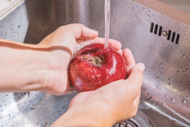 Female hands washing apple