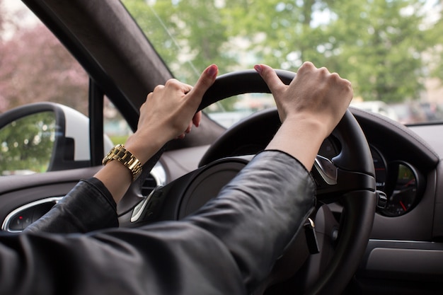 Female hands on the wheel close up