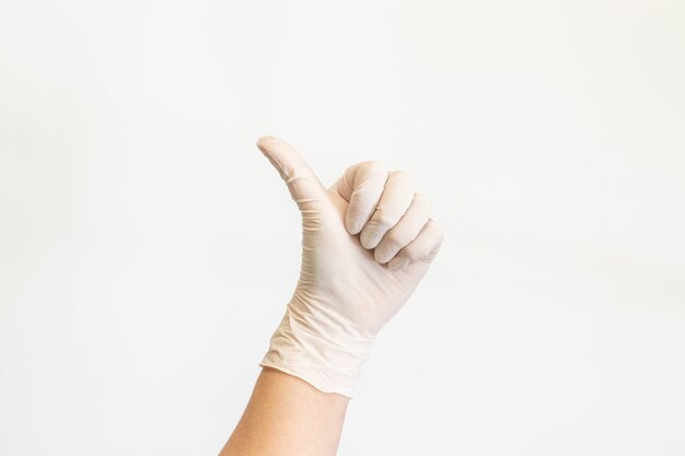 Женские руки в белых медицинских перчатках, показаны как знак.