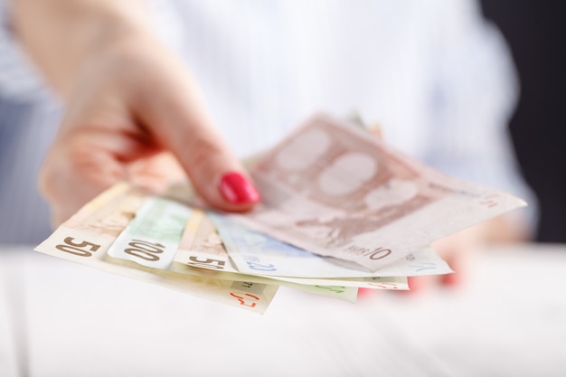 Female hands with banknotes give money