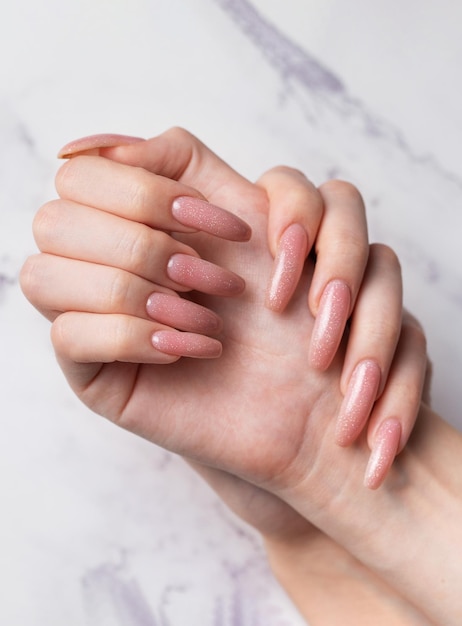 Female hands with beautiful manicure on marble background