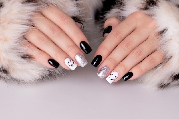 Female hands with black manicure nails, hearts design