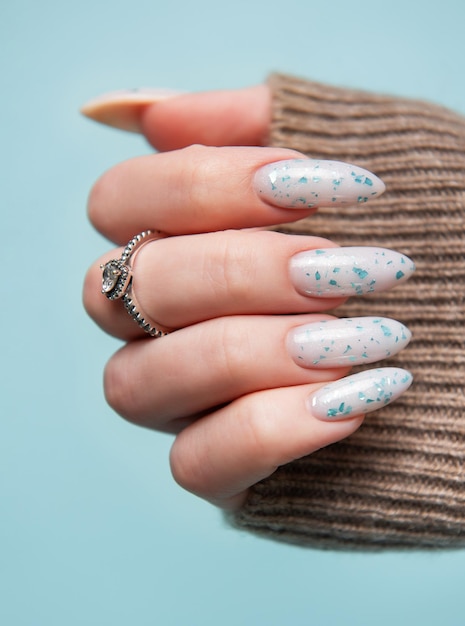 Женские руки с голубым дизайном ногтей Голубой маникюр с лаком для ногтей