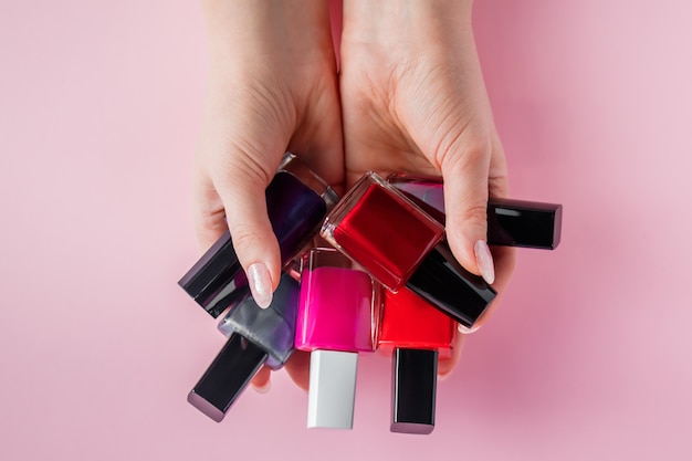 Photo female hands with bright nail polishes.